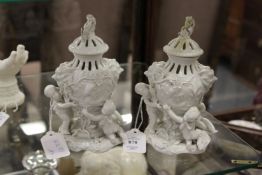 A pair of 19th century white porcelain vases and covers, the base each with three children