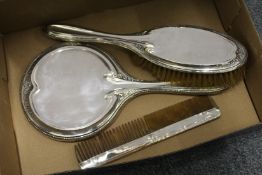 A silver three piece dressing table set.