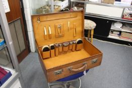 A leather travelling case fitted with silver topped jars and other items.