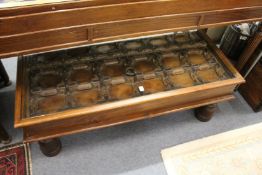 An eastern hardwood and glass topped coffee table converted from a door with wrought iron fittings.