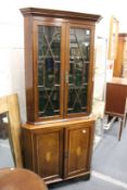 An Edwardian inlaid mahogany standing corner display cabinet with a pair of glazed doors above a