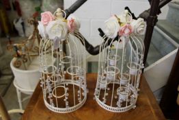 A pair of decorative bird cage style tea light holders.