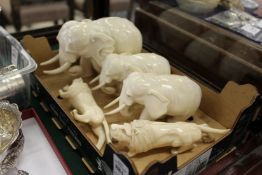 Three carvings depicting elephants and two of lions.