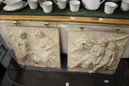 A pair of unusual moulded hanging plaques.