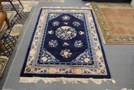A Chinese rug, blue ground with floral and insect decoration.