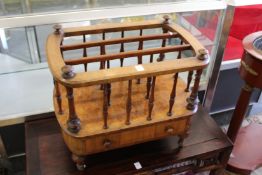 A good Victorian walnut two division Canterbury with a single drawer on turned feet.