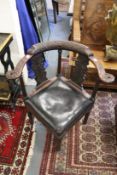 A George III mahogany corner armchair with carved decoration.
