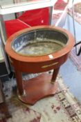 A French red painted and ormolu mounted oval jardiniere on column supports.