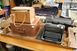An old typewriter, sewing machine, projector and screen.