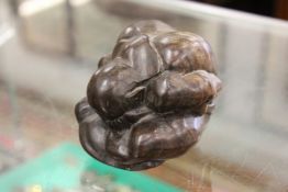 A carved wood model of a crouching man.