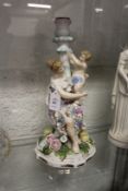 A continental porcelain figural candlestick group.