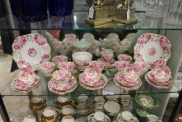 A twelve place tea service, white ground, painted and gilded with pink flowers.