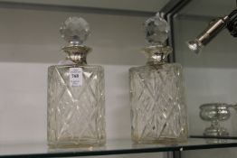 A pair of cut glass and silver mounted whisky decanters.