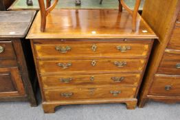 A 19th century mahogany and inlaid four drawer chest with brushing slide on bracket feet.