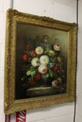 A still life of flowers in a vase on a ledge, oil on board, in a decorative gilt frame