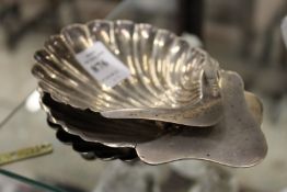 Three silver shell shaped butter dishes.