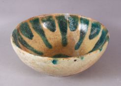 A 12TH CENTURY ABBASID POTTERY BOWL, with a turquoise drip glaze, 23cm