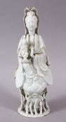 A CHINESE BLANC DE CHINE PORCELAIN FIGURE OF GUANYIN & CHILD, stood upon rising lotus, 22cm.