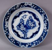A FINE QUALITY CHINESE KANGXI PERIOD BLUE AND WHITE BIRD AND PRUNUS DISH, the base with Artemisia