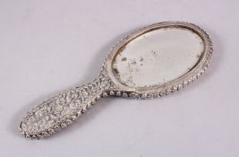 A 19TH CENTURY INDIAN SILVER HAND MIRROR, with embossed decoration of flora, 24cm