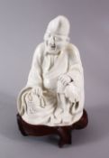 A CHINESE BLANC DE CHINE PORCELAIN FIGURE OF A SEATED SCHOLAR, with a hardwood carved base, (AF)