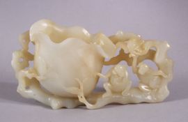 A CHINESE CARVED WHITE JADE LOTUS & MONEY BRUSH WASH, depicting two moneys seated upon the foliage