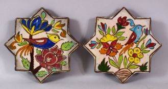 A SMALL PAIR OF IRANIAN POTTERY STAR FORMED TILES, each decorated with scenes of birds and flora,