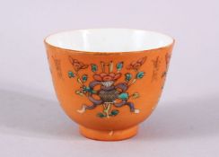 A CHINESE ORANGE GROUND PORCELAIN CUP, with an orange ground and precious object decoration, the