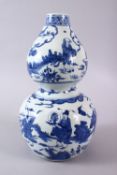 A CHINESE BLUE & WHITE DOUBLE GOURD PORCELAIN VASE, decorated with scenes of immortals shou lao &