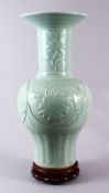 A LARGE CHINESE CELADON PORCELAIN VASE & STAND, the vase decorated with moulded floral decoration,