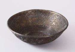 A 19TH CENTURY ISLAMIC CALLIGRAPHIC BRONZE MAGIC BOWL, with carved bands of calligraphy and interior