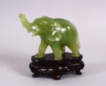 A SMALL CHINESE CARVED JADE FIGURE OF AN ELEPHANT, with a carved hardwood base, 10cm overall high.
