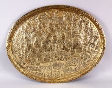A 19TH CENTURY INDIAN EMBOSSED BRASS TRAY, with decoration depicting many scenes of figures and