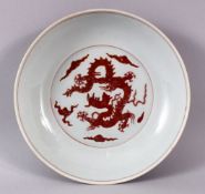 A CHINESE MING STYLE COPPER RED PORCELAIN DRAGON DISH, the interior with moulded relief copper red