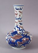 A CHINESE IRON RED & BLUE PORCELAIN BOTTLE STYLE VASE, decorated with lion dogs and ball amongst