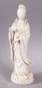 A CHINESE BLANC DE CHINE PORCELAIN FIGURE OF GUANYIN, stood upon a wave form style base, 29cm high.