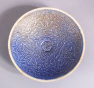 A CHINESE MOULDED BLUE GLAZED DISH, with fish and floral decoration, 13cm