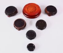 A MIXED LOT OF 7 CHINESE CARVED WOODEN STANDS, each of varying style and size, largest 15cm diameter