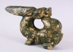 A CHINESE CARVED HARDSTONE FIGURE OF A DRAGON, in archaic form, looking behind, 26cm wide.
