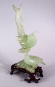 A CHINESE CARVED GREEN JADE FIGURE OF TWO BIRDS, both seated upopn a naturalistic formed branch,