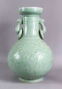 A LARGE CHINESE CELADON PORCELAIN TWIN HANDLE VASE, the body with carved floral decoration beneath a