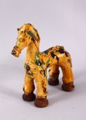 A TURKISH CANAKKALE POTTERY FIGURE OF A HORSE, with green and brown splash decoration upon a biscuit