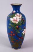 A JAPANESE MEIJI PERIOD CLOISONNE VASE, the blue ground with native display of flora, 24cm high