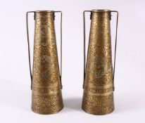 A PAIR OF PERSIAN BRASS ENGRAVED VASES, with twin handles, carved panels of figures and foliage,