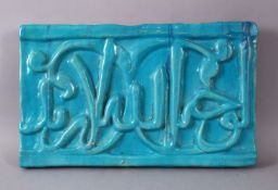 A GOOD IRAN KASHAN TURQUOISE GLAZED POTTERY CALLIGRAPHIC PANEL, with a turquoise glaze over