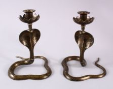 A PAIR OF INDIAN COBRA SNAKE FORMED CANDLE STICKS, the sticks in the form of cobras, with chased and