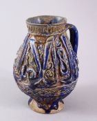 AN EARLY PERSIAN KASHAN BLUE MOULDED POTTERY JUG, with calligraphy to the body and animals, 17cm