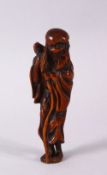A JAPANESE EDO / MEIJI CARVED BOXWOOD NETSUKE OF A SENNIN, stood holding his staff, himotoshi formed
