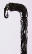 A CEYLONESE EBONY CARVED ELEPHANT WALKING STICK, with an elephant handle and ivory tusks, 92cm