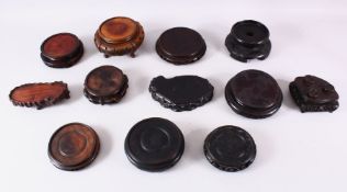 A MIXED LOT OF 12 CHINESE CARVED HARDWOOD STANDS - each of varying size, style and timber, the